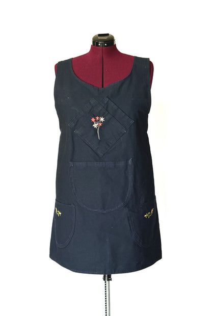 Black apron with floral design on a mannequin against a white background
